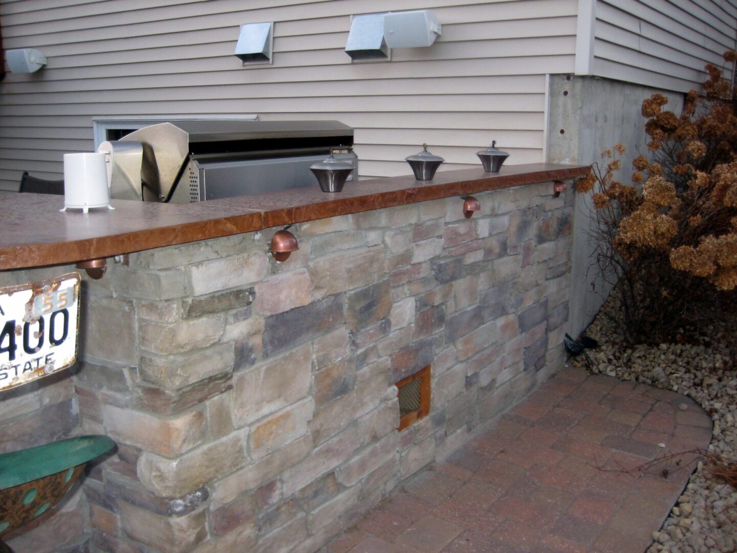 Outdoor counter with gray bricks and brown marble countertops