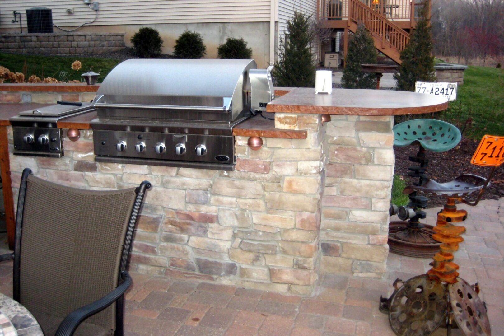 Outdoor grill on top of a brick counter with brown marble countertops