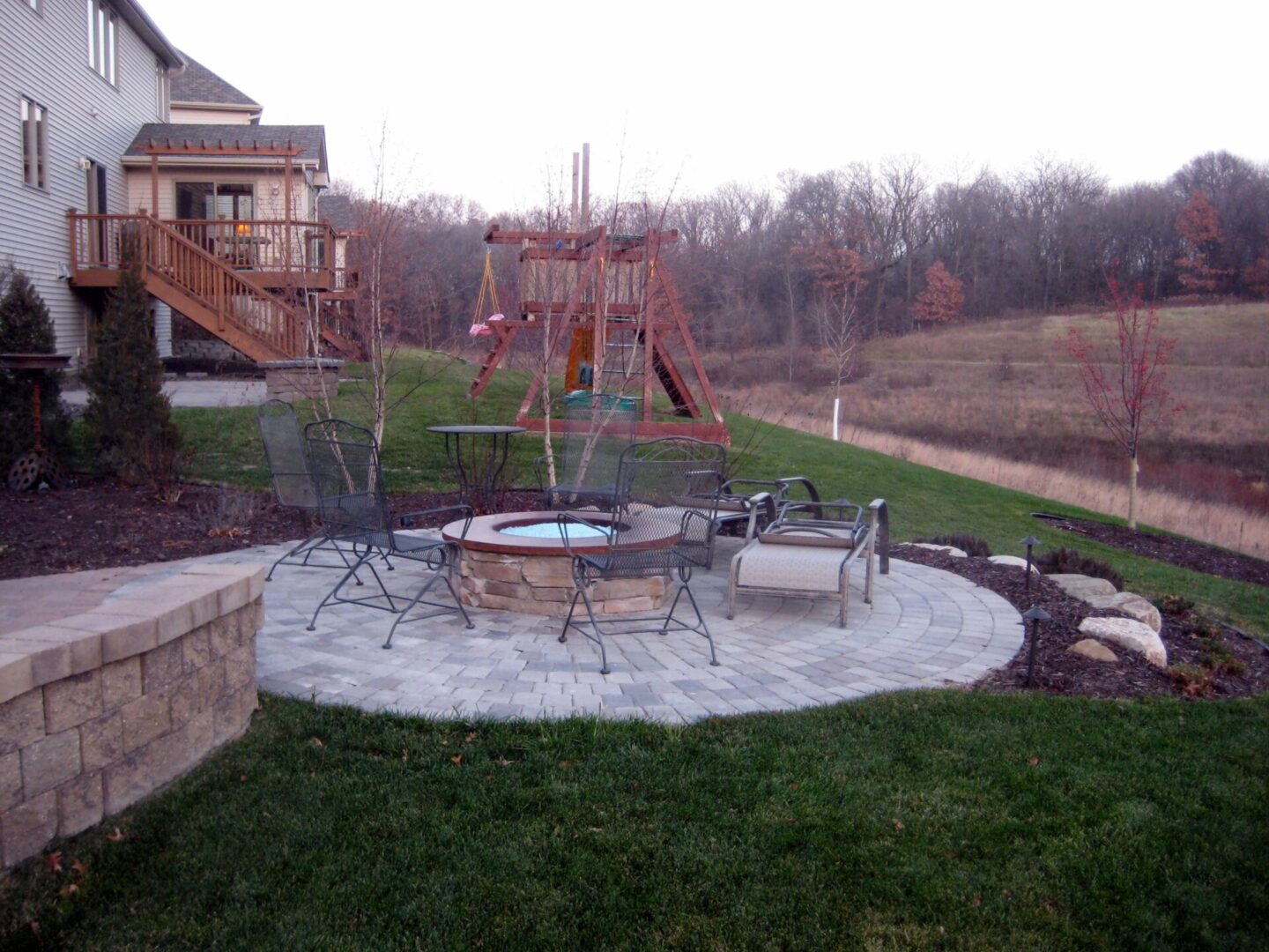 Paved outdoor firepit area with metal chairs