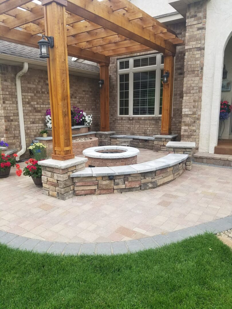 Outdoor fire pit under a wooden patio arches with decorative flowers in pots