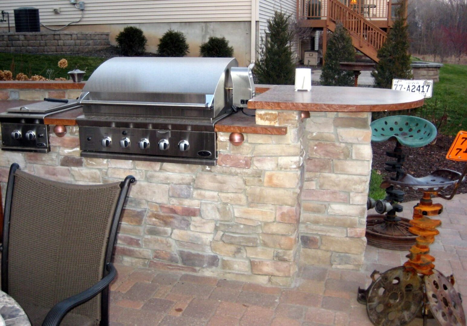Outdoor grill on top of a brick counter with brown marble countertops